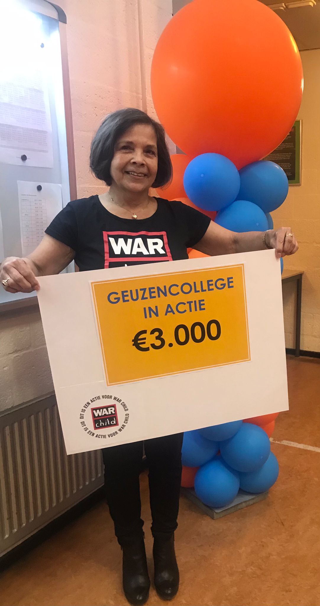 Charlotte Hartmann van War Child ontvangt cheque Geuzencollege